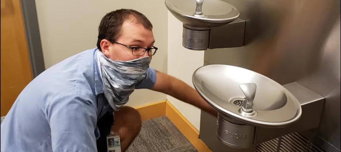 Jordan Smith from ATF, Inc. cleans the often-used water fountains in the office.